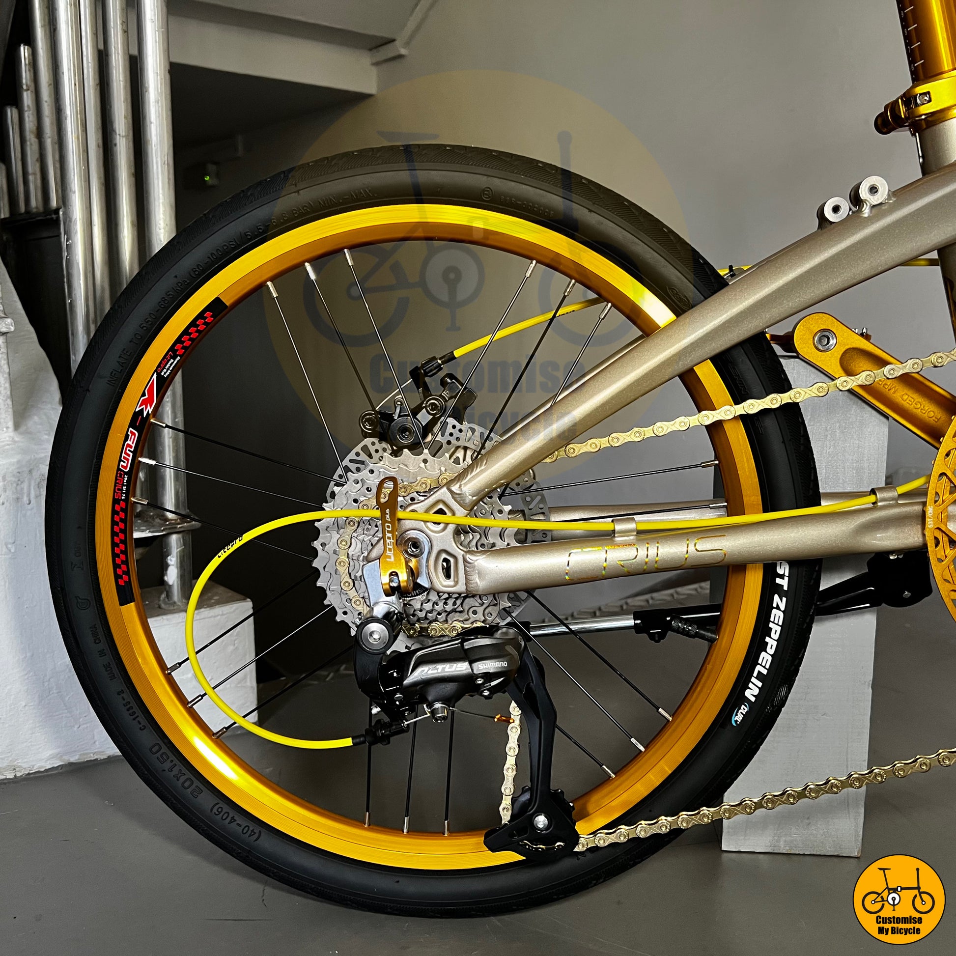 Rear wheel and drivetrain of Crius Velocity 22-inch, featuring gold accents and Shimano gear system