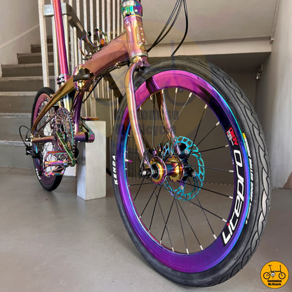 Compact folding bicycle with oil slick saddle for stylish city rides
