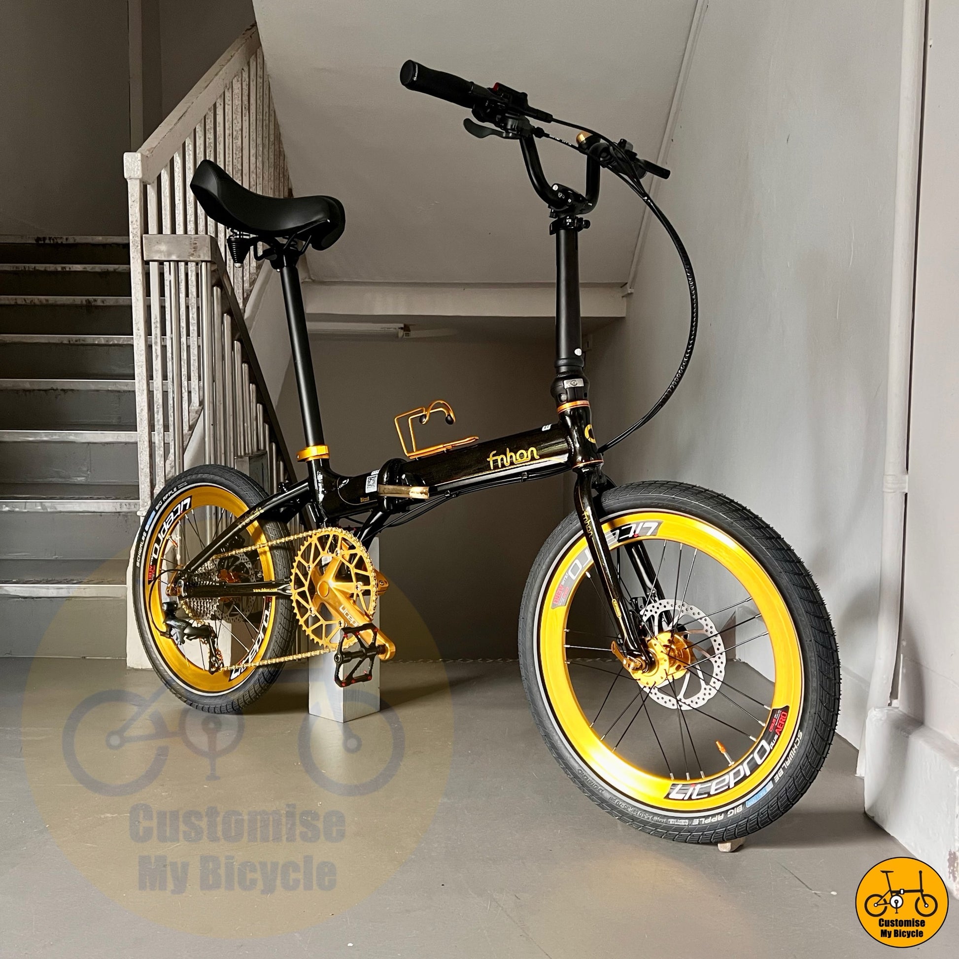 Black and yellow bicycle leaning against a wall indoors