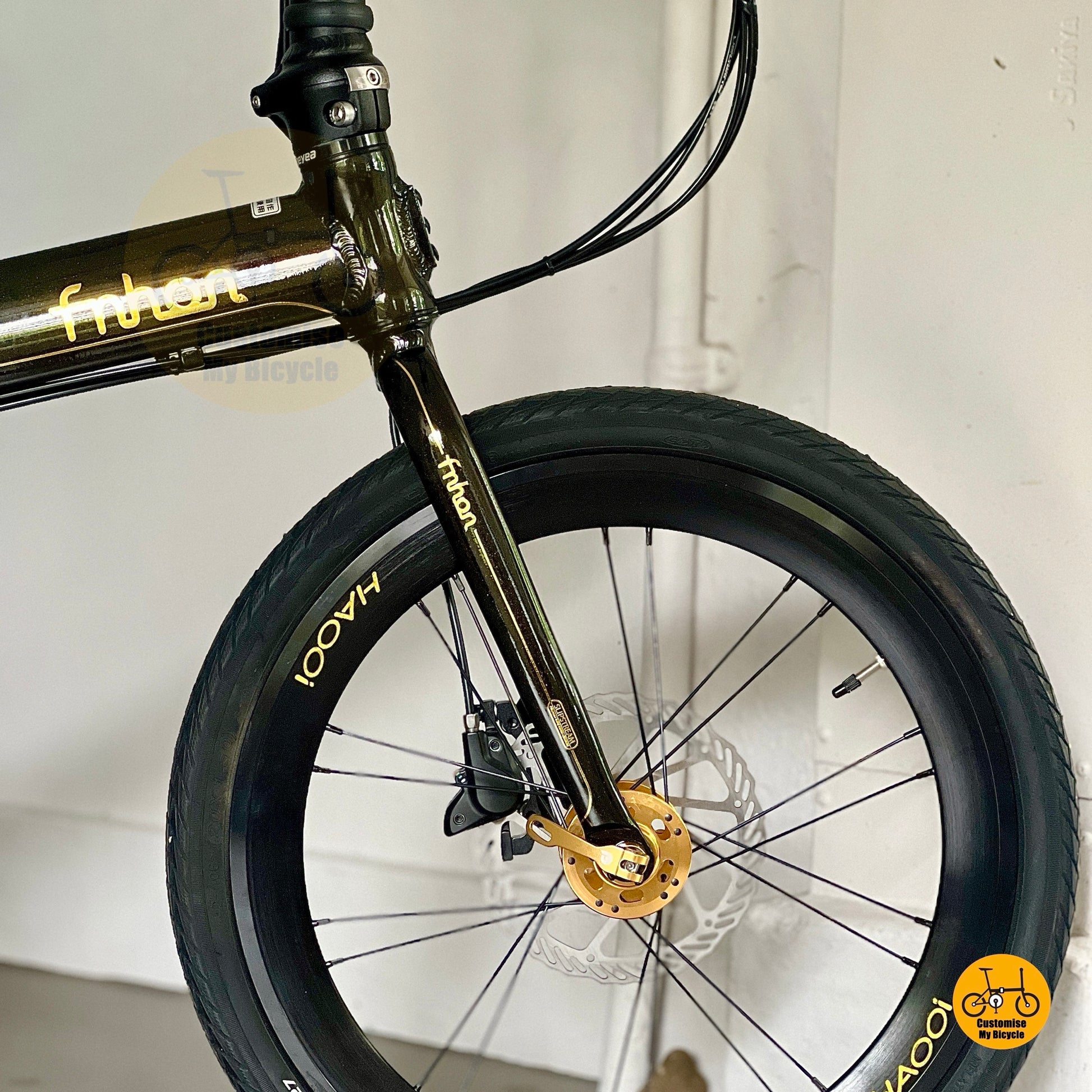 Close up of front wheel black gold HAOOI aero profile rim with CST tyre details
