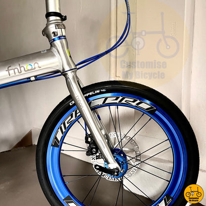 Tiralpro Aero wheelset with vibrant blue accents on folding bike
