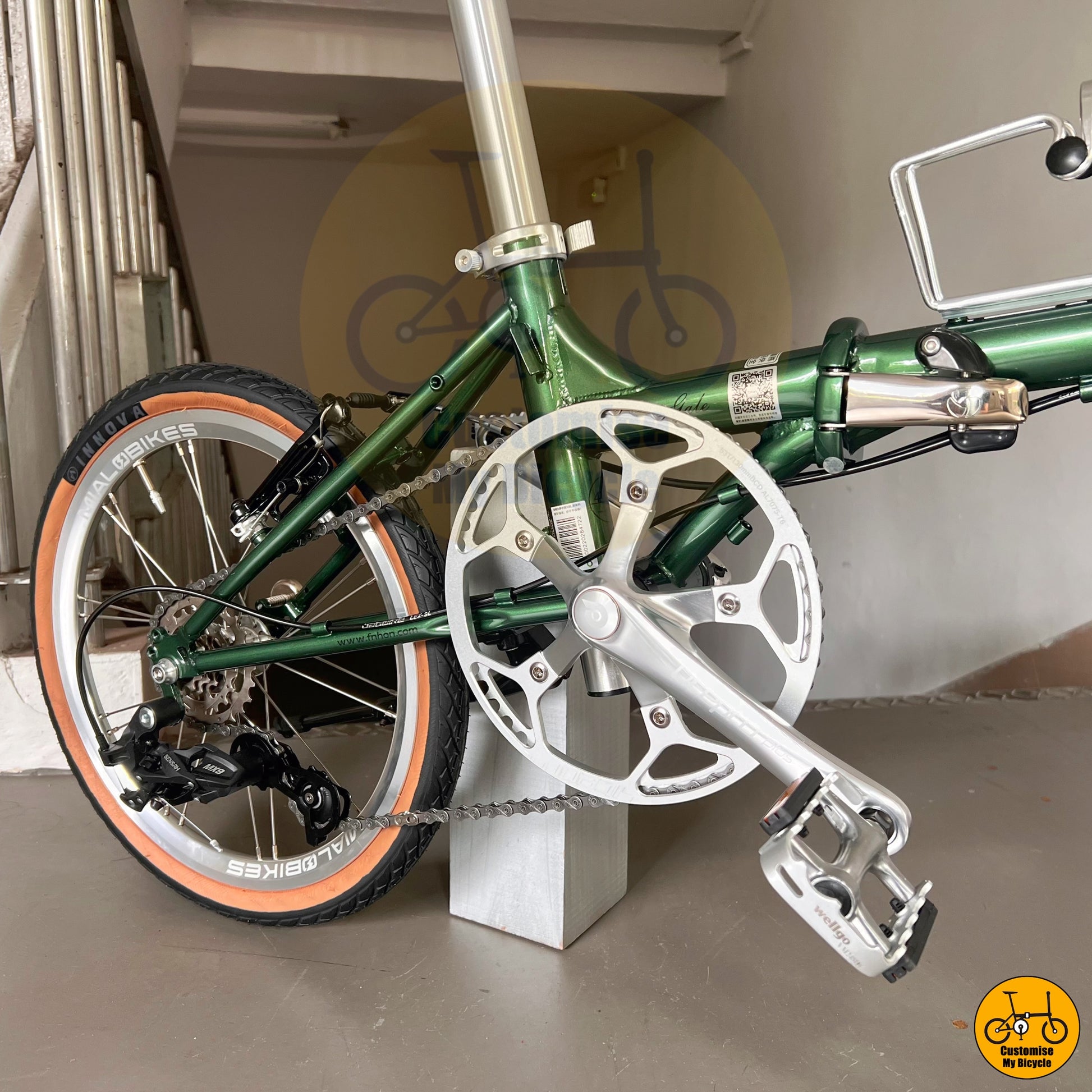 Emerald green foldable bicycle with brown saddle and grips
