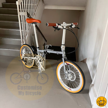 Folding bike with retro themed silver and brown parts  

