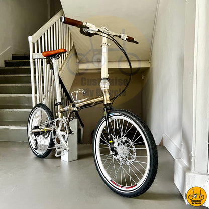Titanium gold foldable bike designed for efficient city commuting and touring
