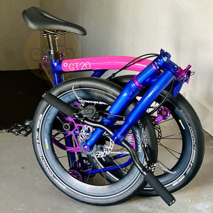 A folded fnhon GT20 bicycle with a vibrant metallic blue frame, a bright pink seat tube, and purple accents,