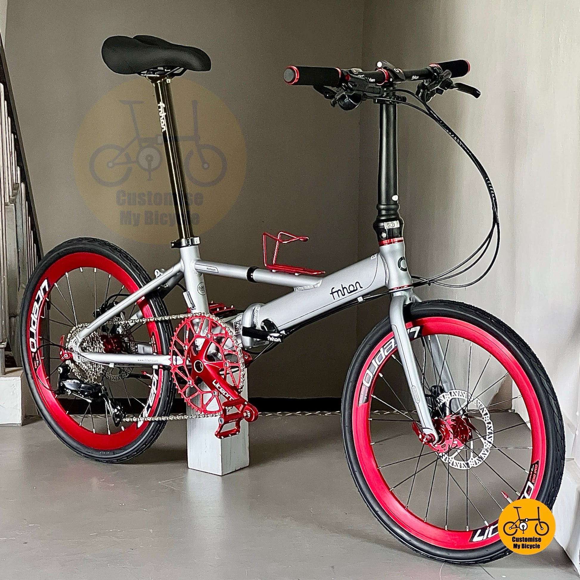 Side view of 22 inch folding bicycle with red crank and wheels  
