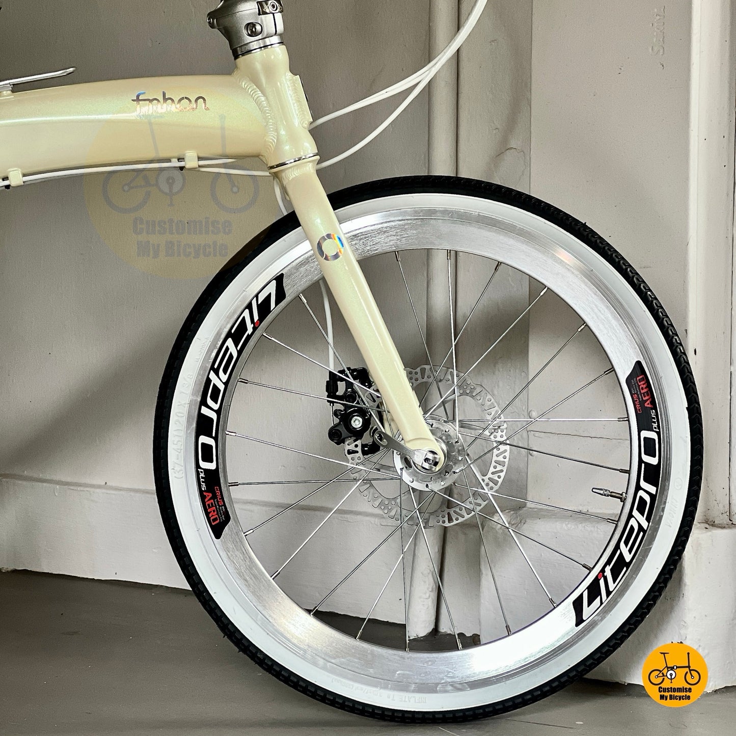 Foldable beige bicycle with white wall tyres  
