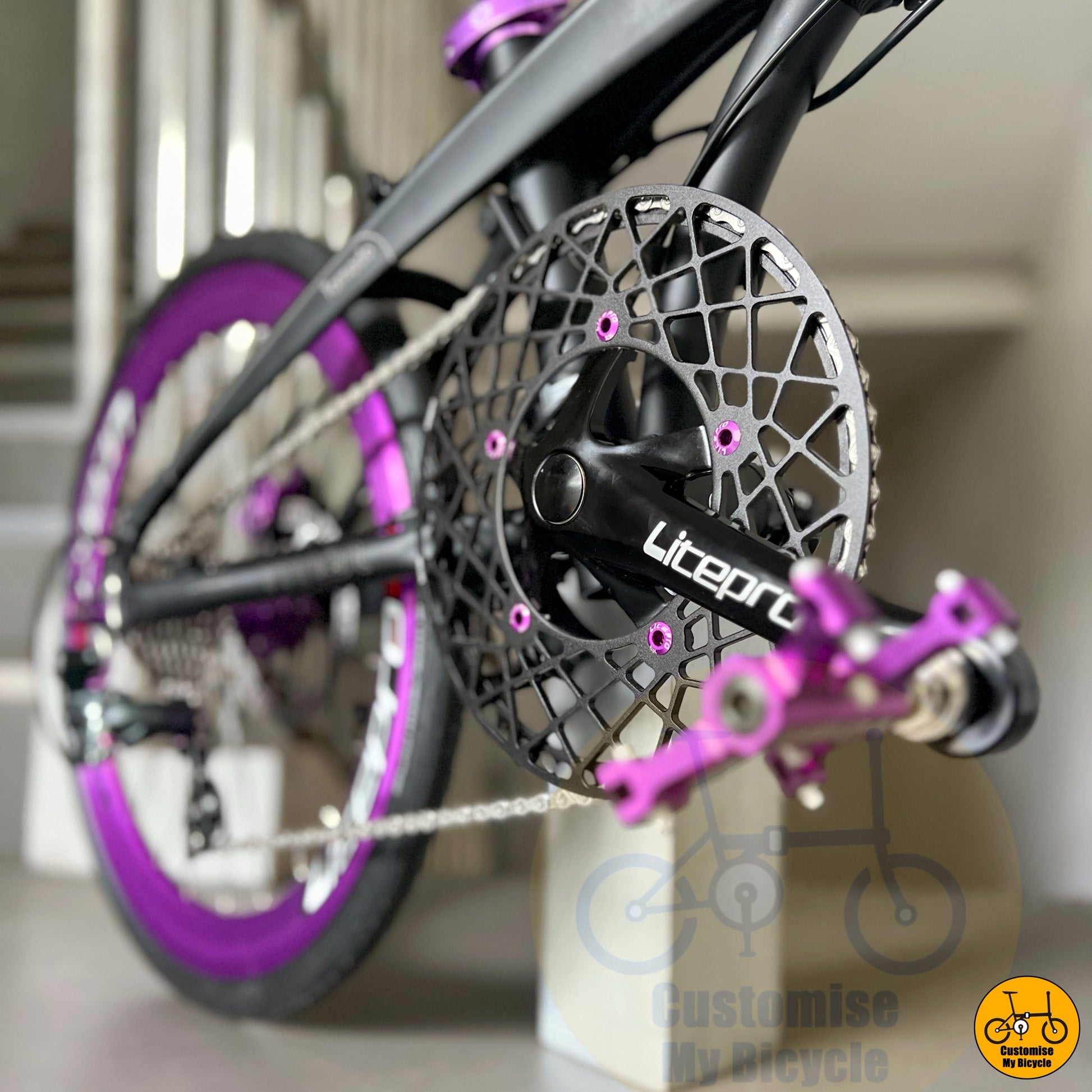 custom crankset and pedals on matte black frame
