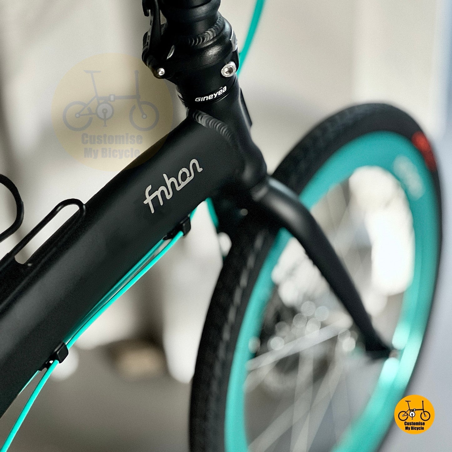 Lightweight black folding bike with teal accents  
